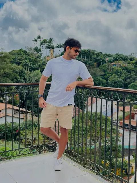 Vinicius Soares sorrindo em uma varanda com vista para a natureza